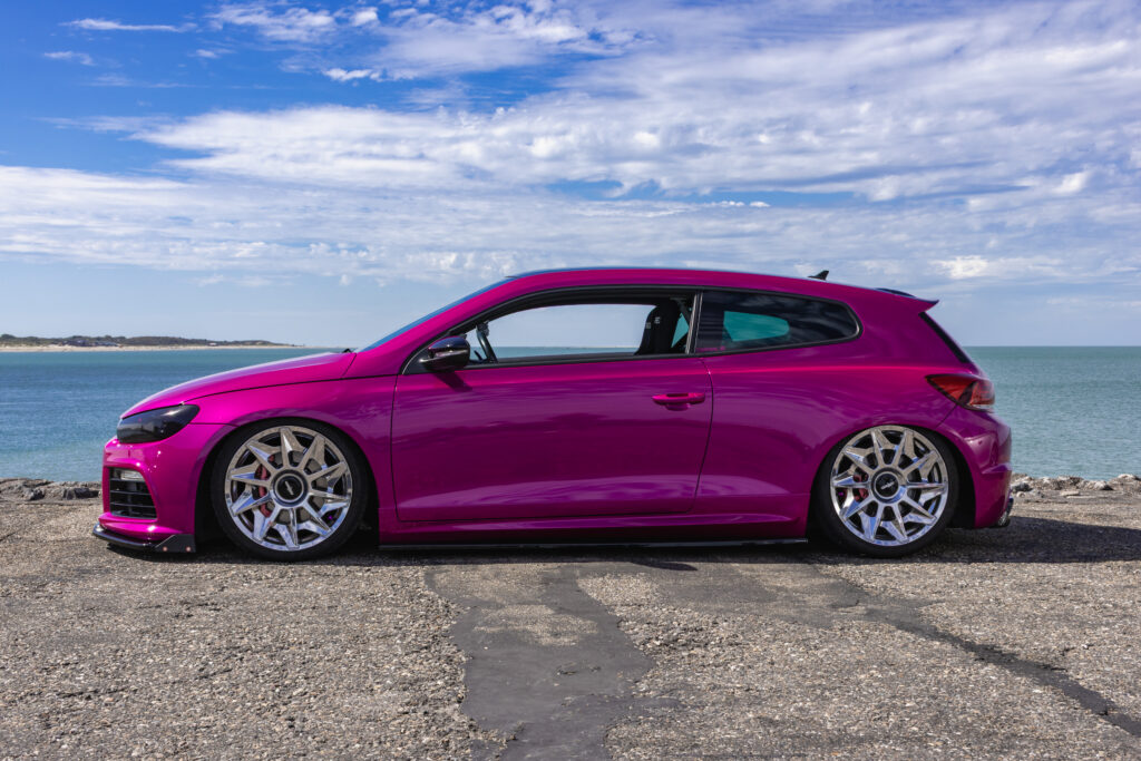 Roze Volkswagen Scirocco gefotografeerd aan het water